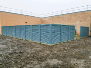 Outside corner view of blue-gray metal louvered screening system