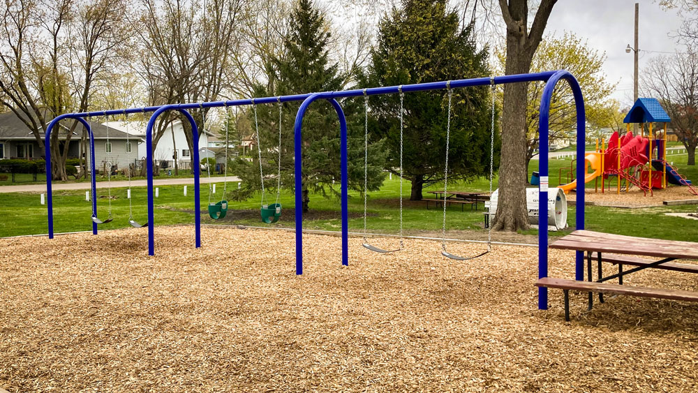 Swing set with blue metal frame for small residential park. Playground company Kearney, Nebraska playground installation playground equipment slides swings surfacing climbers children recreation safety durable