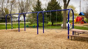 Swing set with blue metal frame for small residential park. Playground company Kearney, Nebraska playground installation playground equipment slides swings surfacing climbers children recreation safety durable